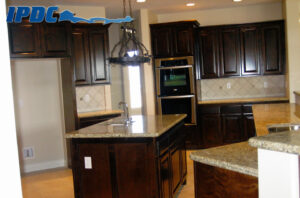 Renovated kitchen with dark brown cabinets and tan countertops.