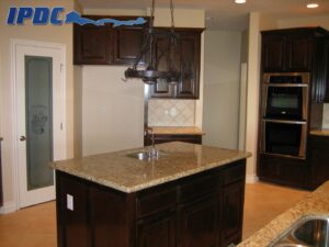 Renovated kitchen with dark brown cabinets and tan countertops.